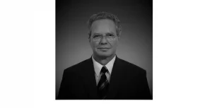 Portrait photo of Dr. Matthias Scholz, founder of LTB Lasertechnik Berlin, in black and white with suit and tie.